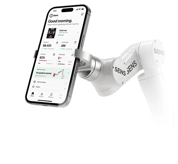SENS robotic arm holding a phone with the revenue, inventory, and machine health dashboard